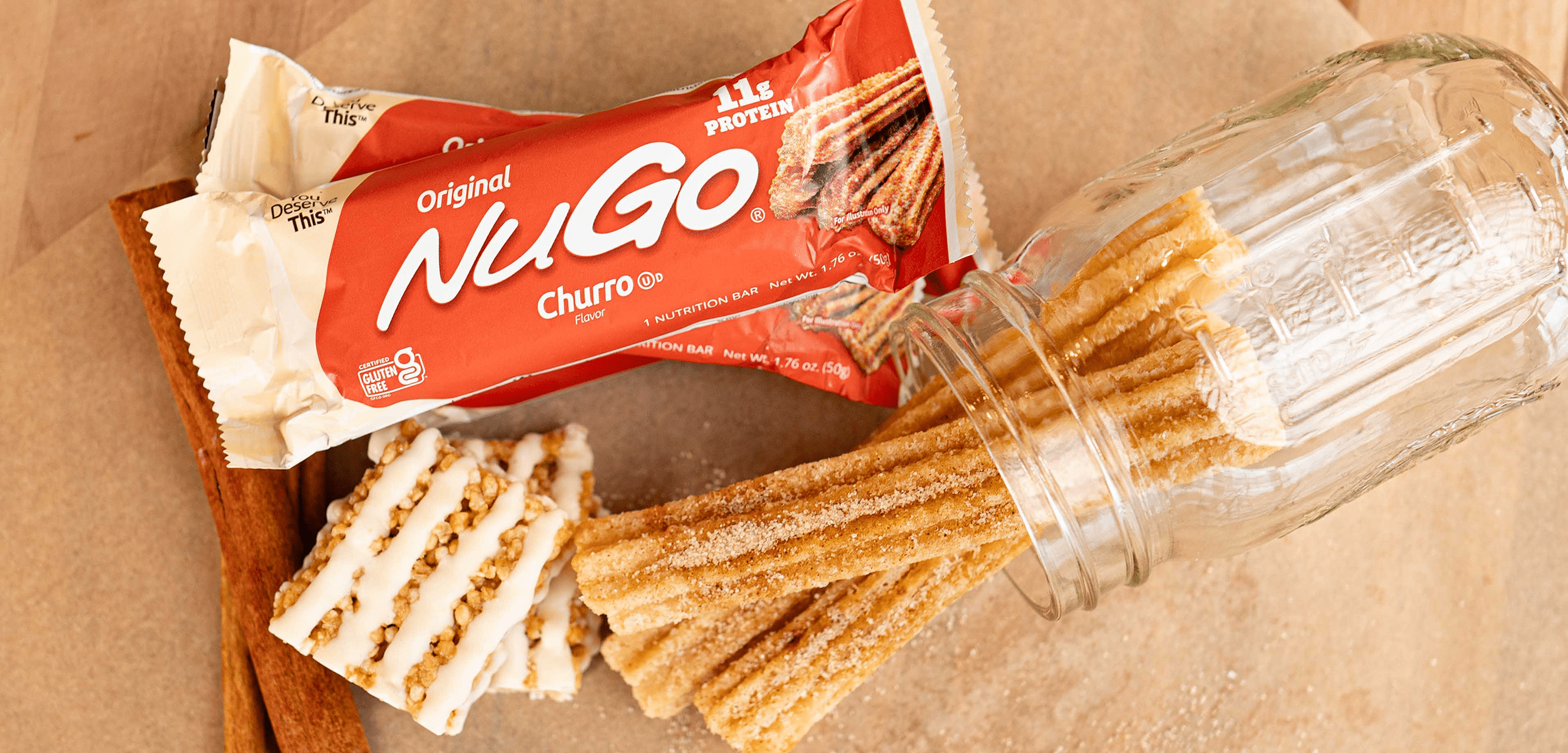 Churro bar next to wrapper and cinnamon sticks